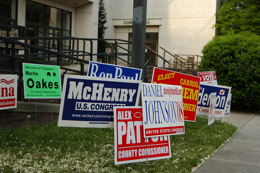 A bunch of signs outside of a polling place during the election